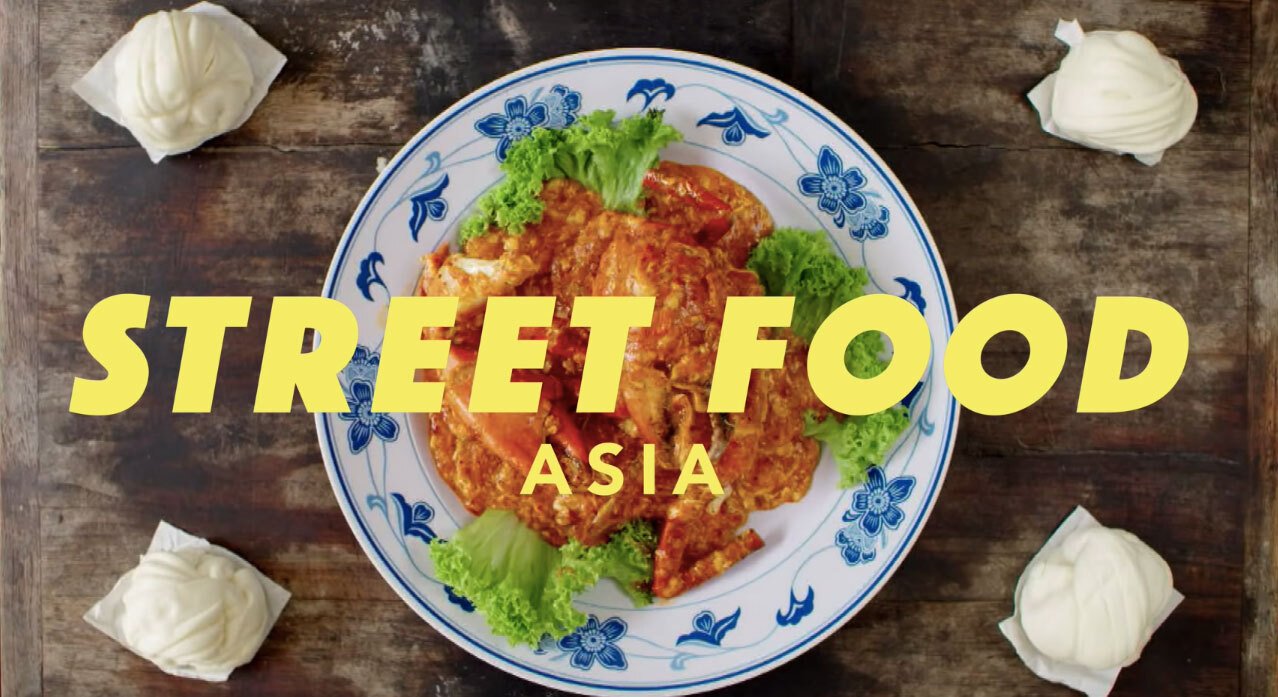 Foto hidangan kepiting di atas meja kayu dengan tulisan Street Food Asia